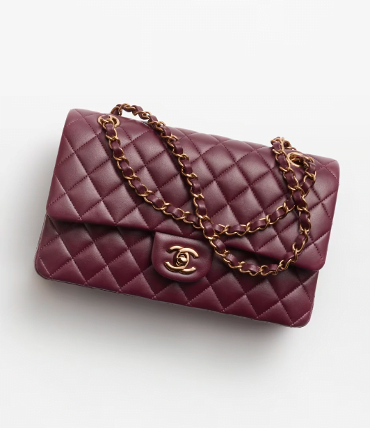 A burgundy quilted Chanel Classic 11.12 bag with gold hardware and a gold chain strap.