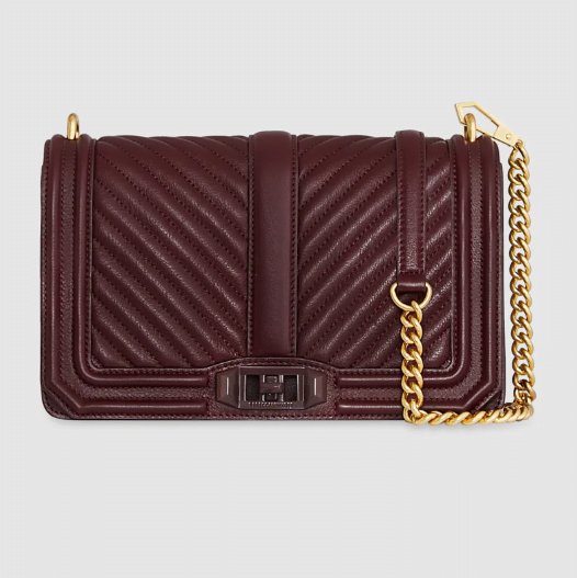 A burgundy quilted crossbody bag with gold hardware and a gold chain strap.